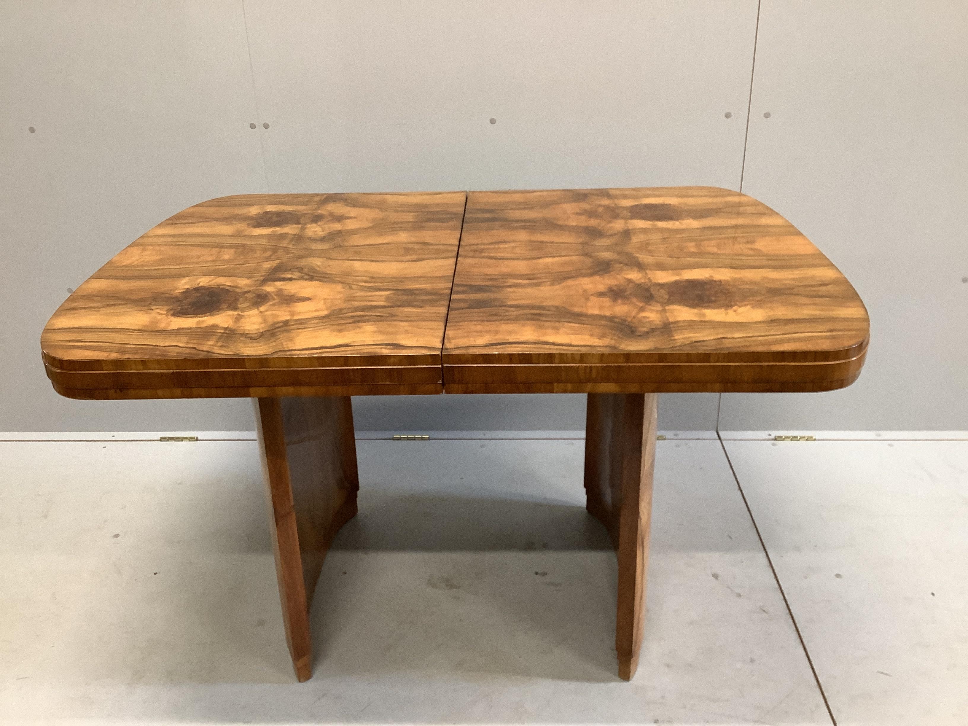 An Art Deco figured walnut rectangular extending dining table, length 167cm extended, one spare leaf, width 91cm, height 77cm